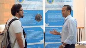 OPCW staff member Farid Tata (right) explains the work of the organisation to a conference attendee.